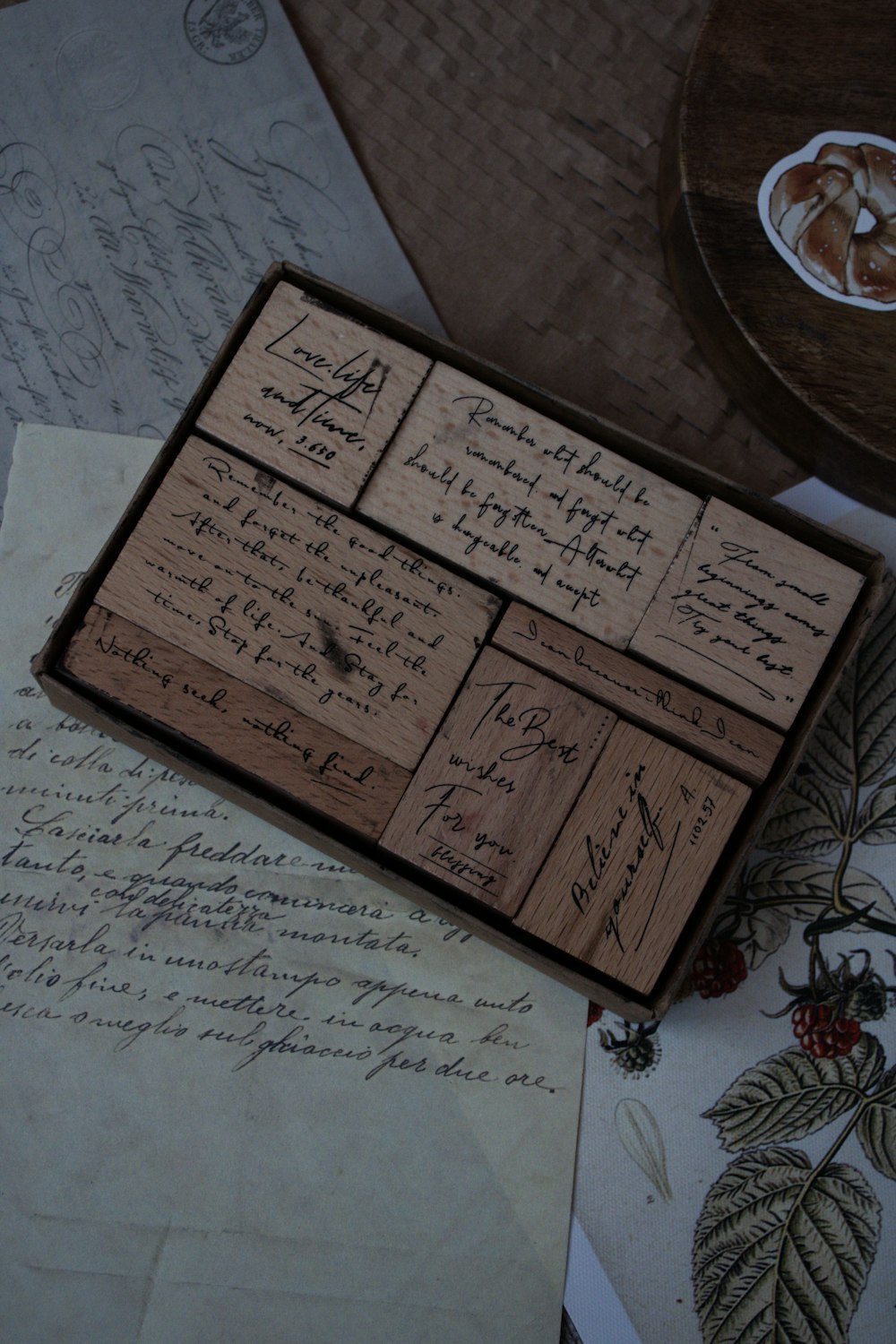 a wooden box filled with lots of writing on top of a table