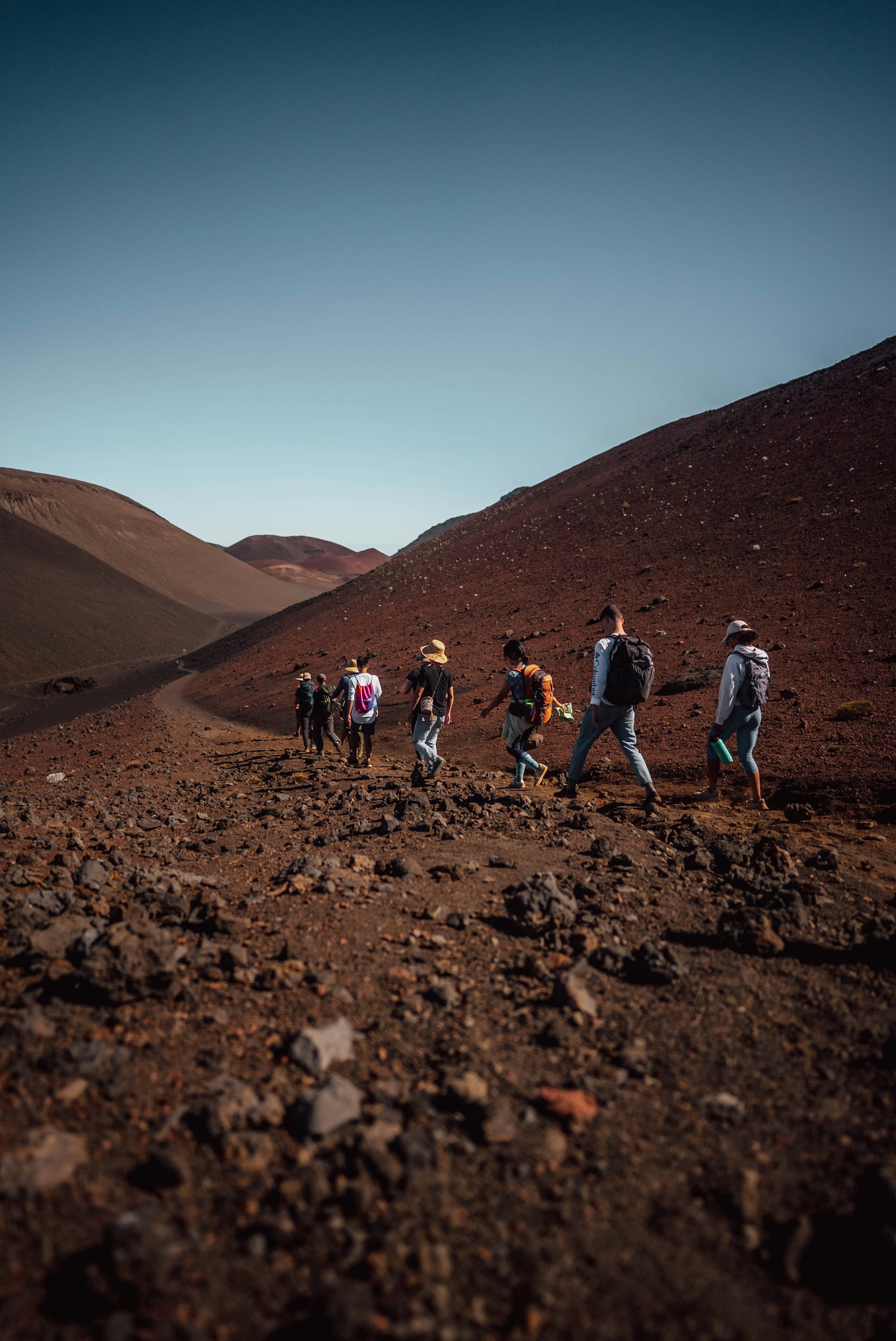 a group of people walking across a dirt field