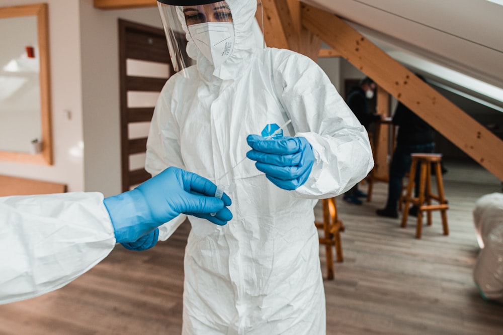 Una persona con traje blanco y guantes azules