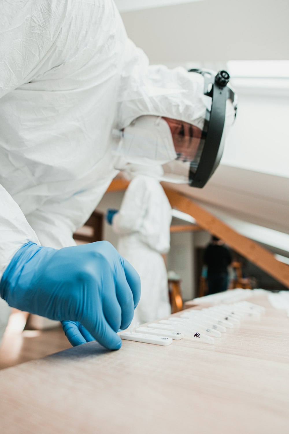 a person wearing a white suit and blue gloves