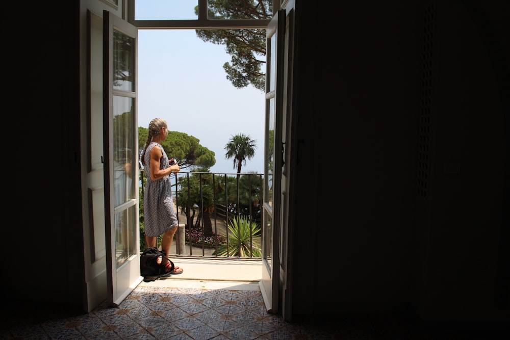 a man standing in a doorway looking out at the ocean