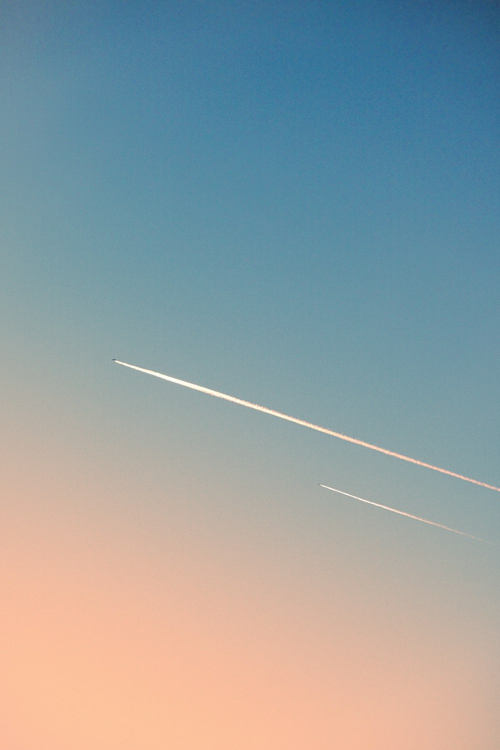 an airplane is flying in the sky with a contrail