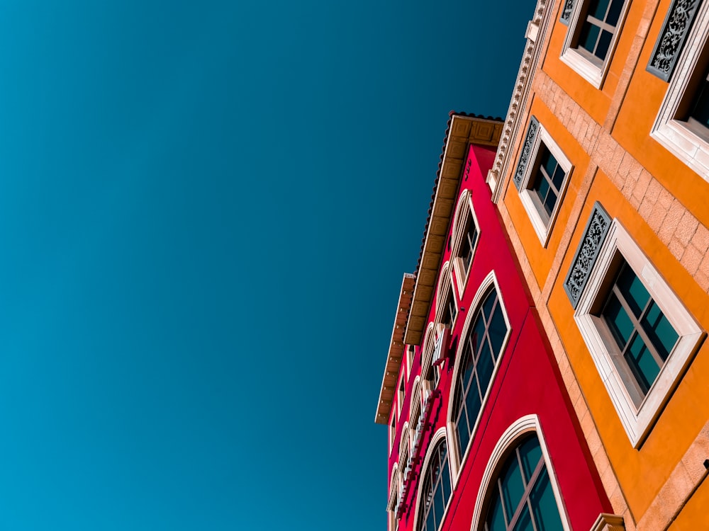 a red and yellow building with a blue sky in the background