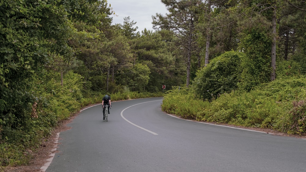 a man riding a bike down a curvy road