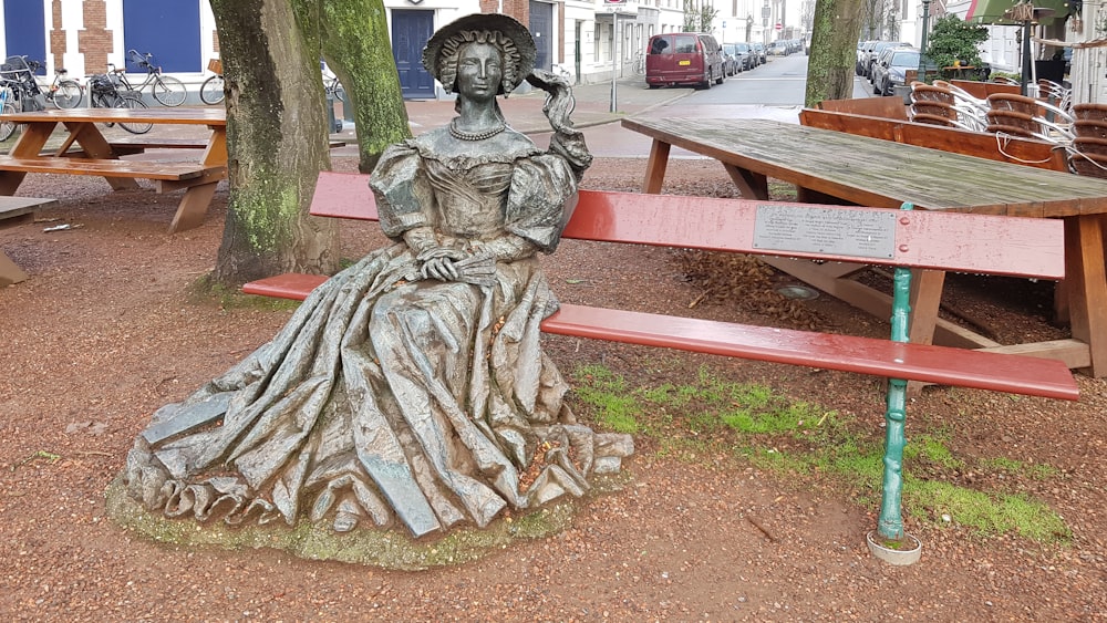 a statue of a woman sitting on a bench