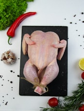 a raw chicken sitting on top of a cutting board