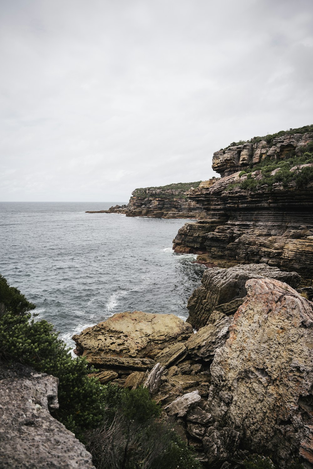 a large body of water sitting next to a rocky shore