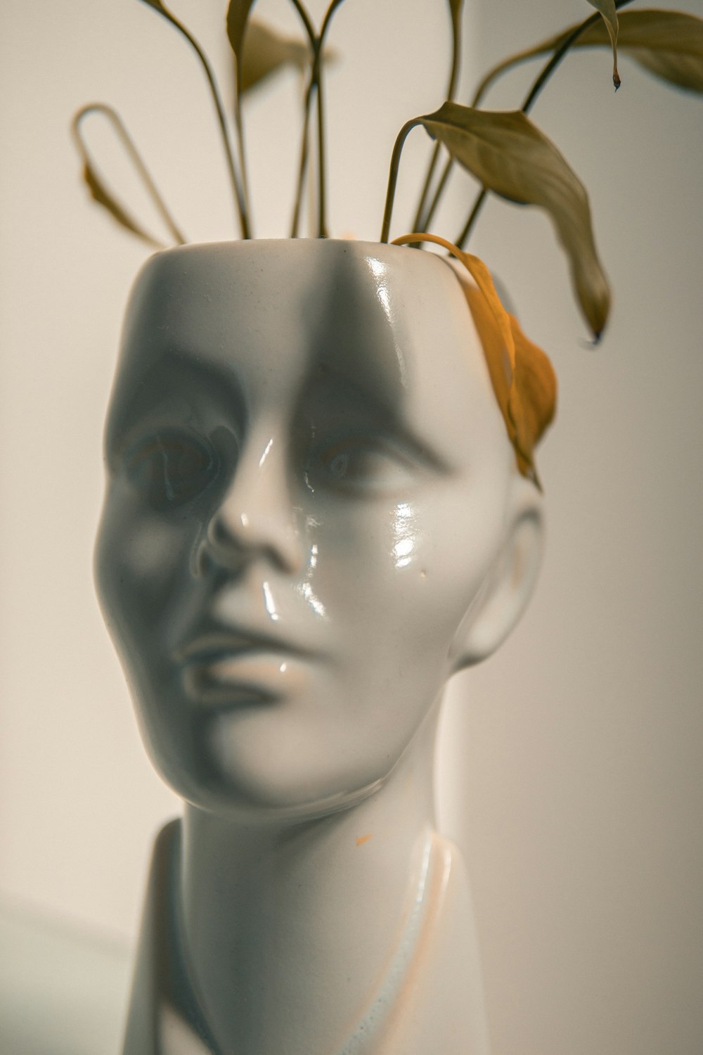 a white mannequin head with flowers in it