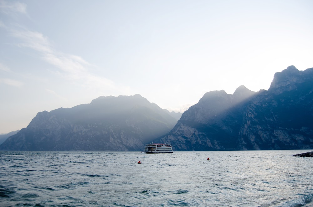 a boat in a body of water with mountains in the background