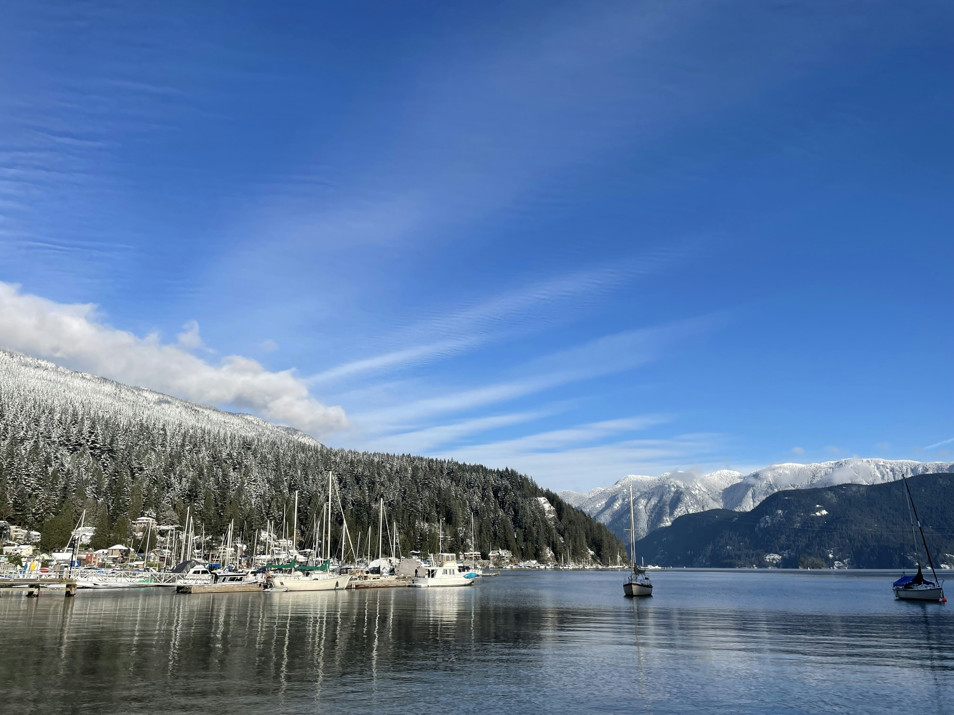 a body of water surrounded by snow covered mountains