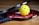 a yellow tennis ball sitting on top of a racket