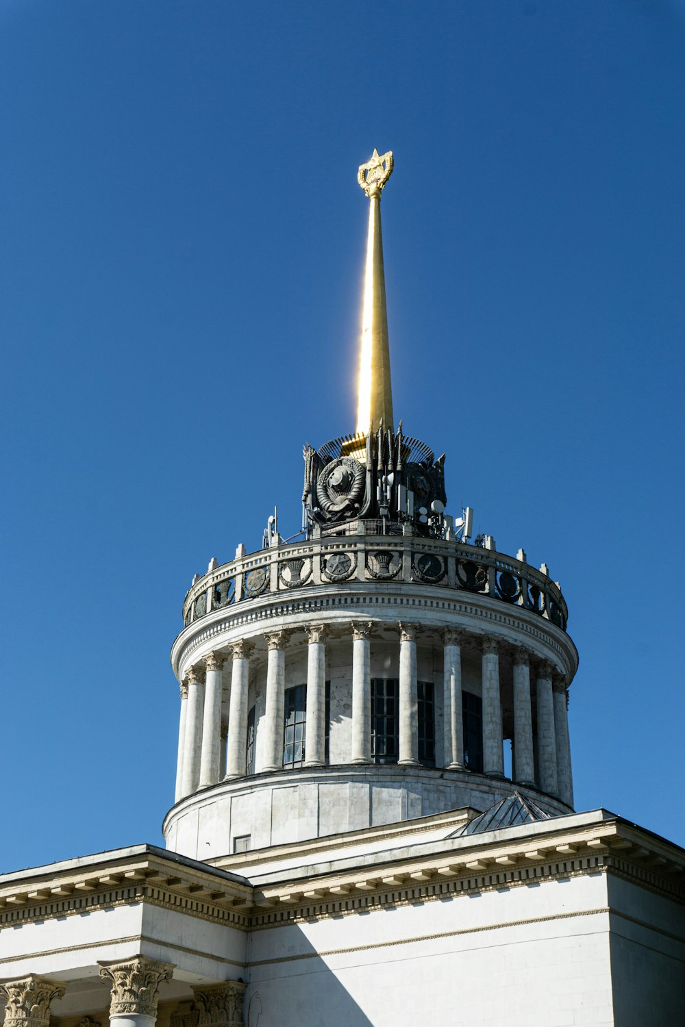 die Spitze eines Gebäudes mit einem goldenen Kreuz auf der Spitze