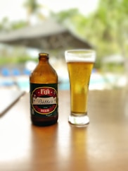 a bottle of beer next to a glass on a table