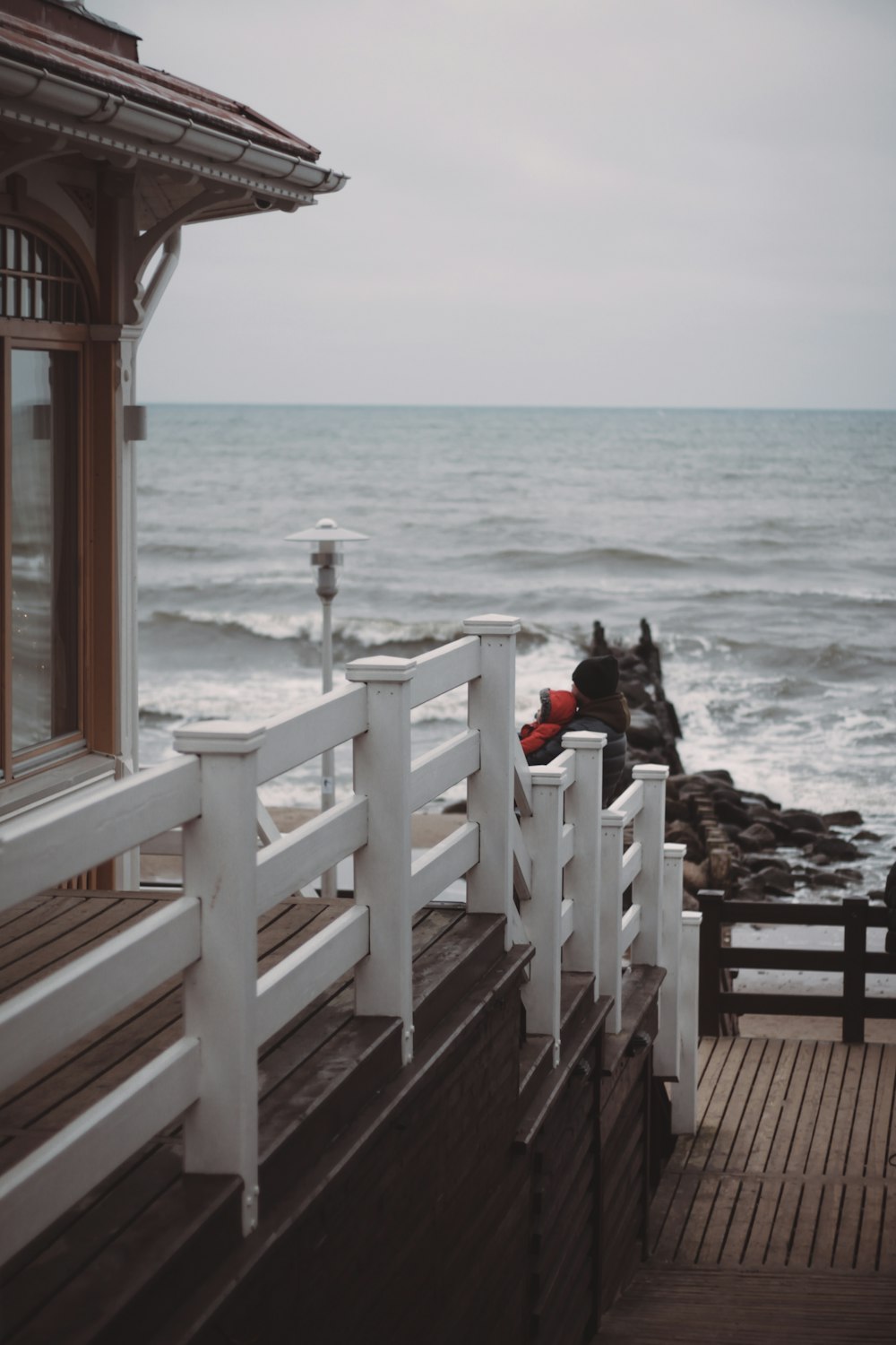 a wooden pier next to the ocean on a cloudy day