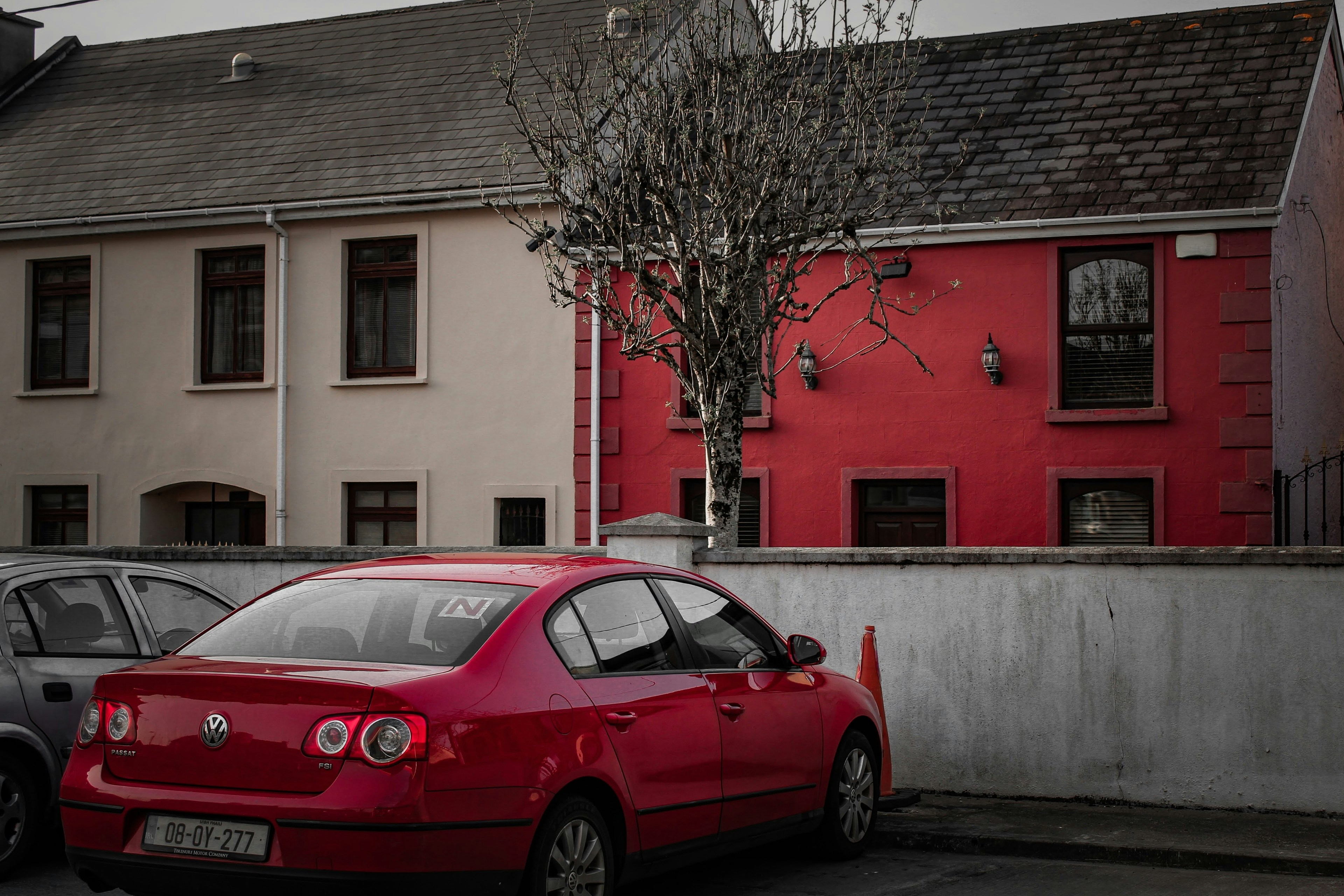 a red car parked in front of a red building