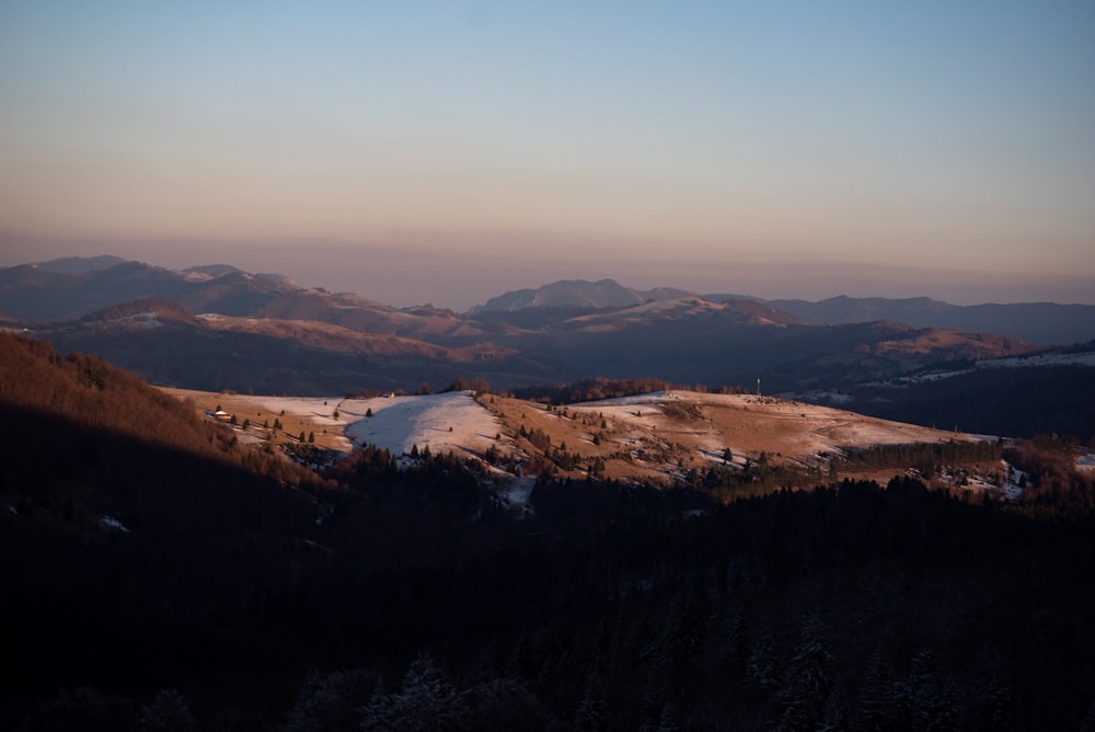 a view of a snowy mountain range at sunset