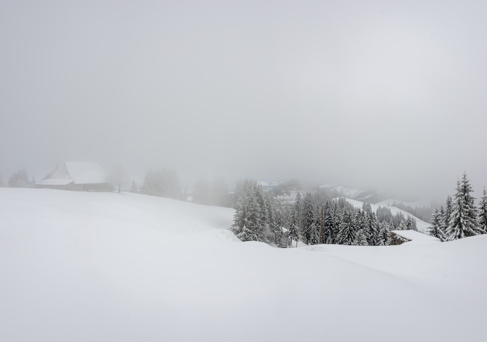 a snow covered hill with a house in the distance