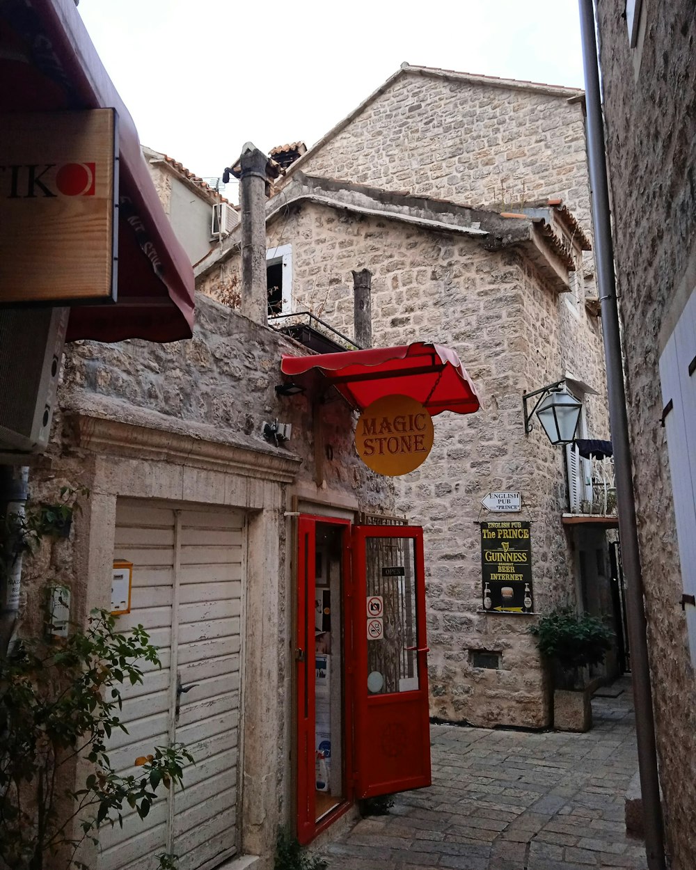 an alleyway with a red door and a red awning