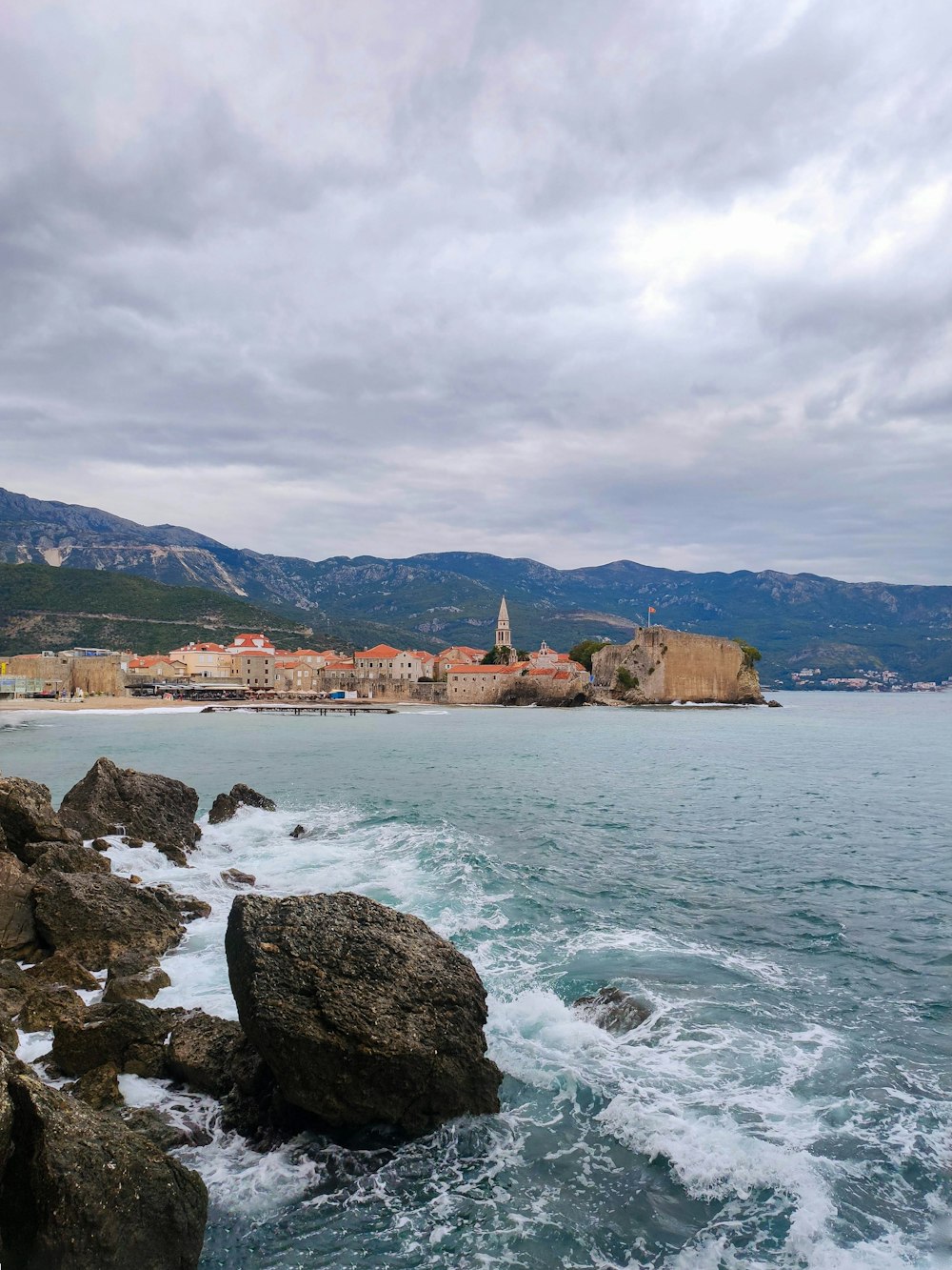 a view of the ocean and a city from a rocky shore