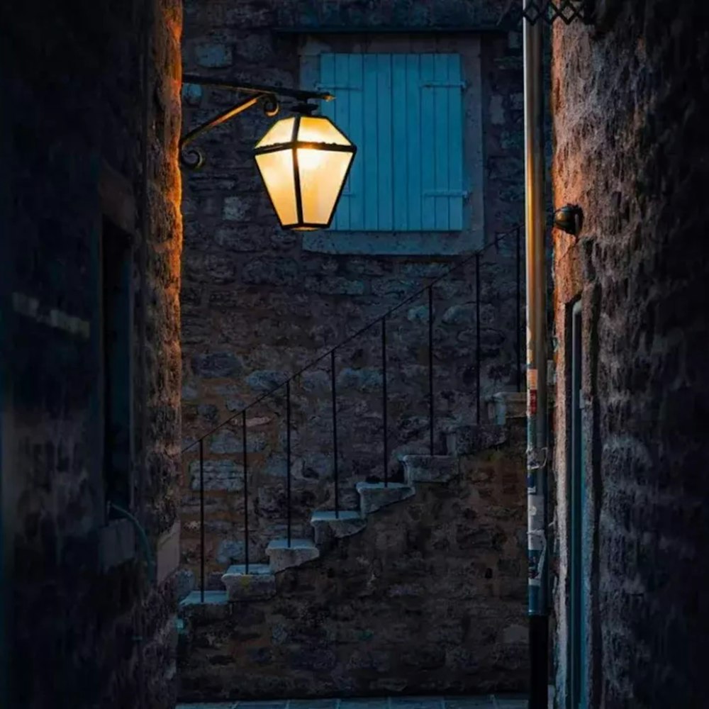 a street light hanging from the side of a brick building