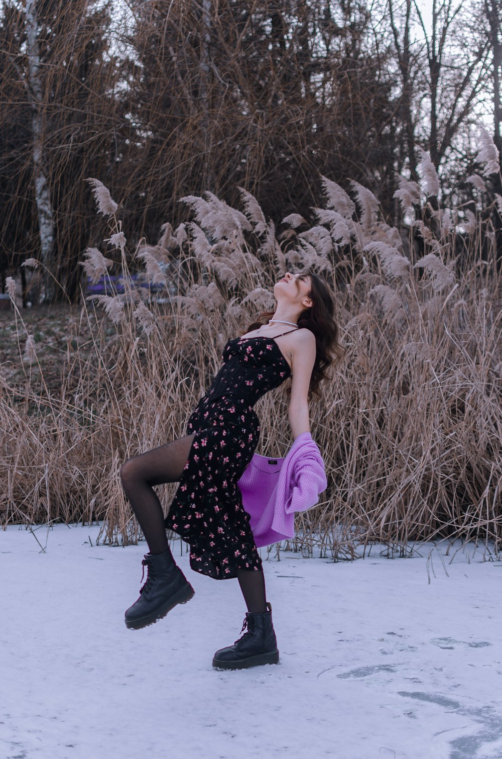 a woman standing in the snow with her legs crossed