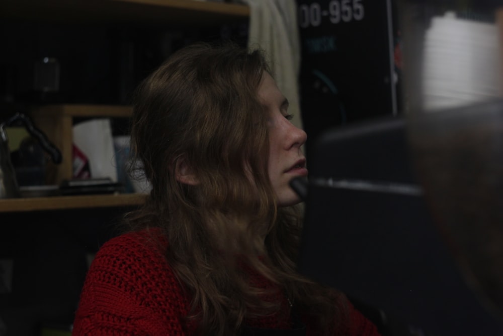 a woman sitting in front of a computer monitor