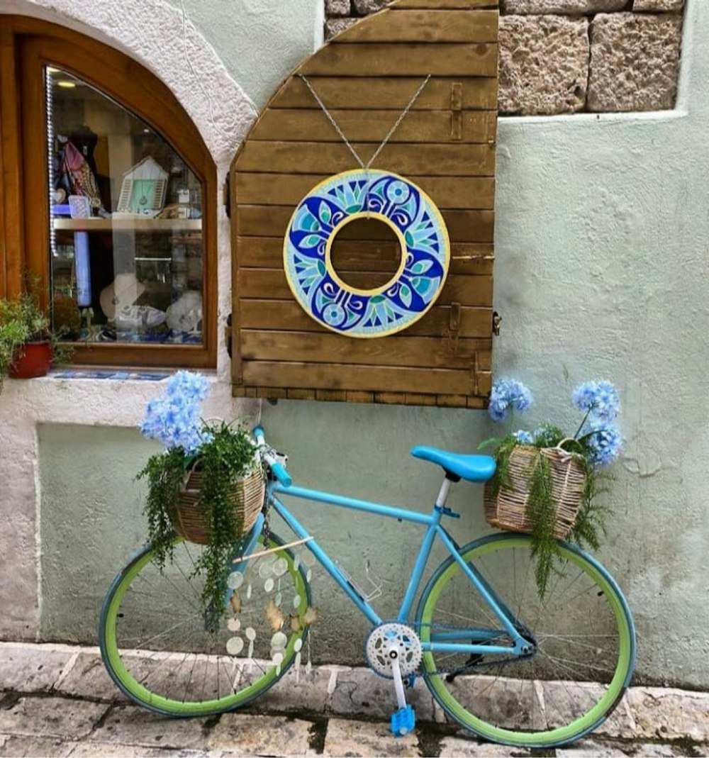 a blue and green bicycle parked in front of a building