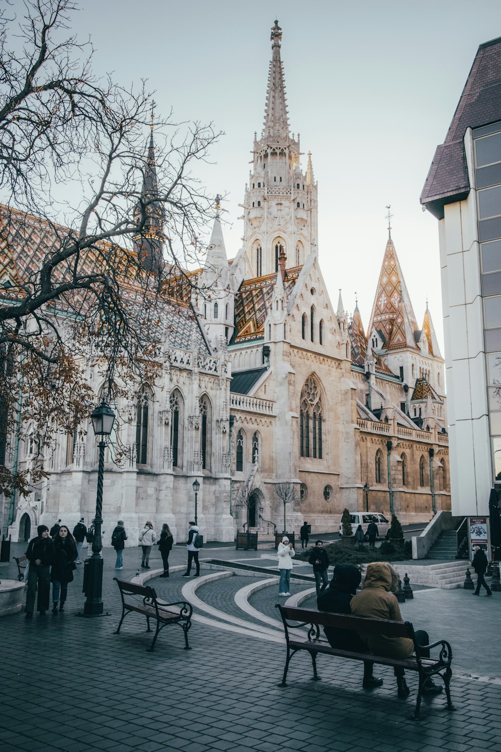 a group of people sitting on benches in front of a building