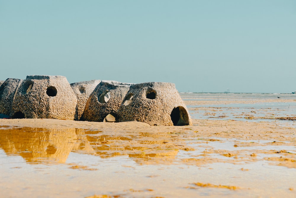 a group of rocks sitting on top of a sandy beach