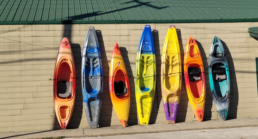 a row of kayaks lined up against a wall