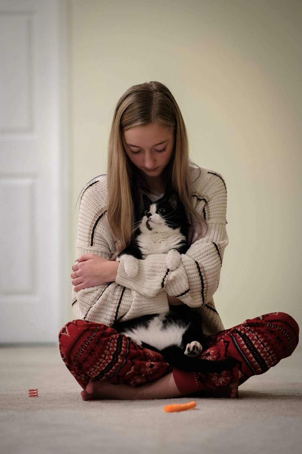 a woman sitting on the floor with a cat in her lap