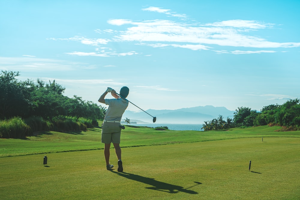 a man swinging a golf club on a golf course