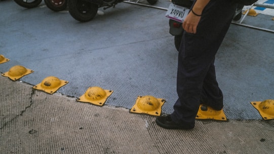 a man standing on a sidewalk next to a parking meter