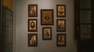 Close-up of vintage composer portraits hanging on a warmly lit gallery wall.