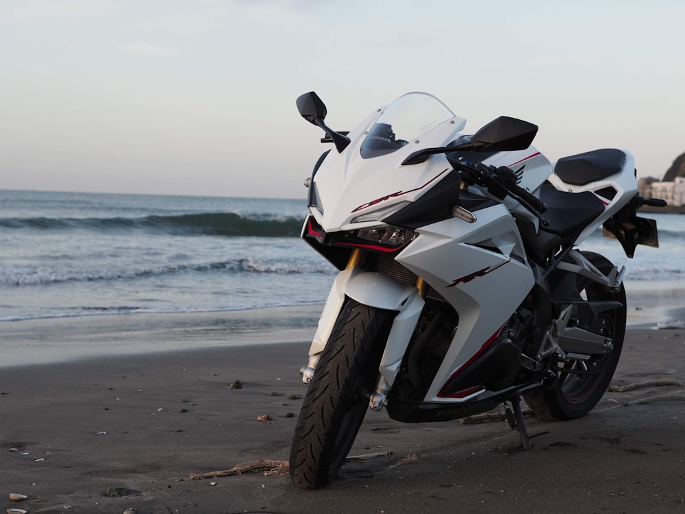 a motorcycle parked on a beach near the ocean