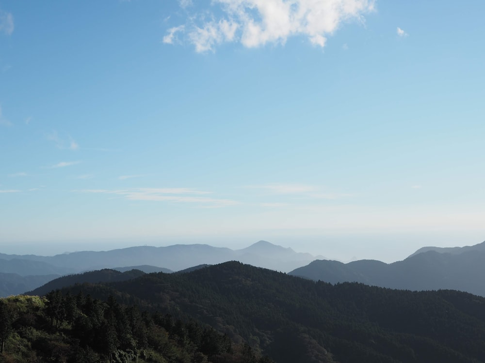 a view of a mountain range with trees and mountains in the background