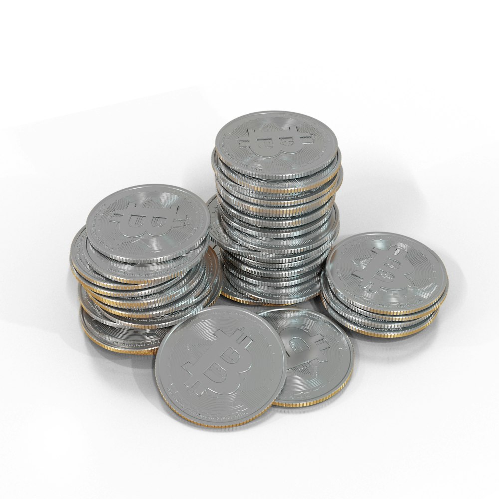 a pile of silver bitcoins sitting on top of each other