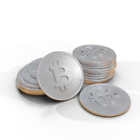 A pile of shiny silver coins decorated with a prominent Bitcoin symbol on the surface. Each coin is meticulously detailed, with engraved text encircling the central logo, indicating a digital currency motif.