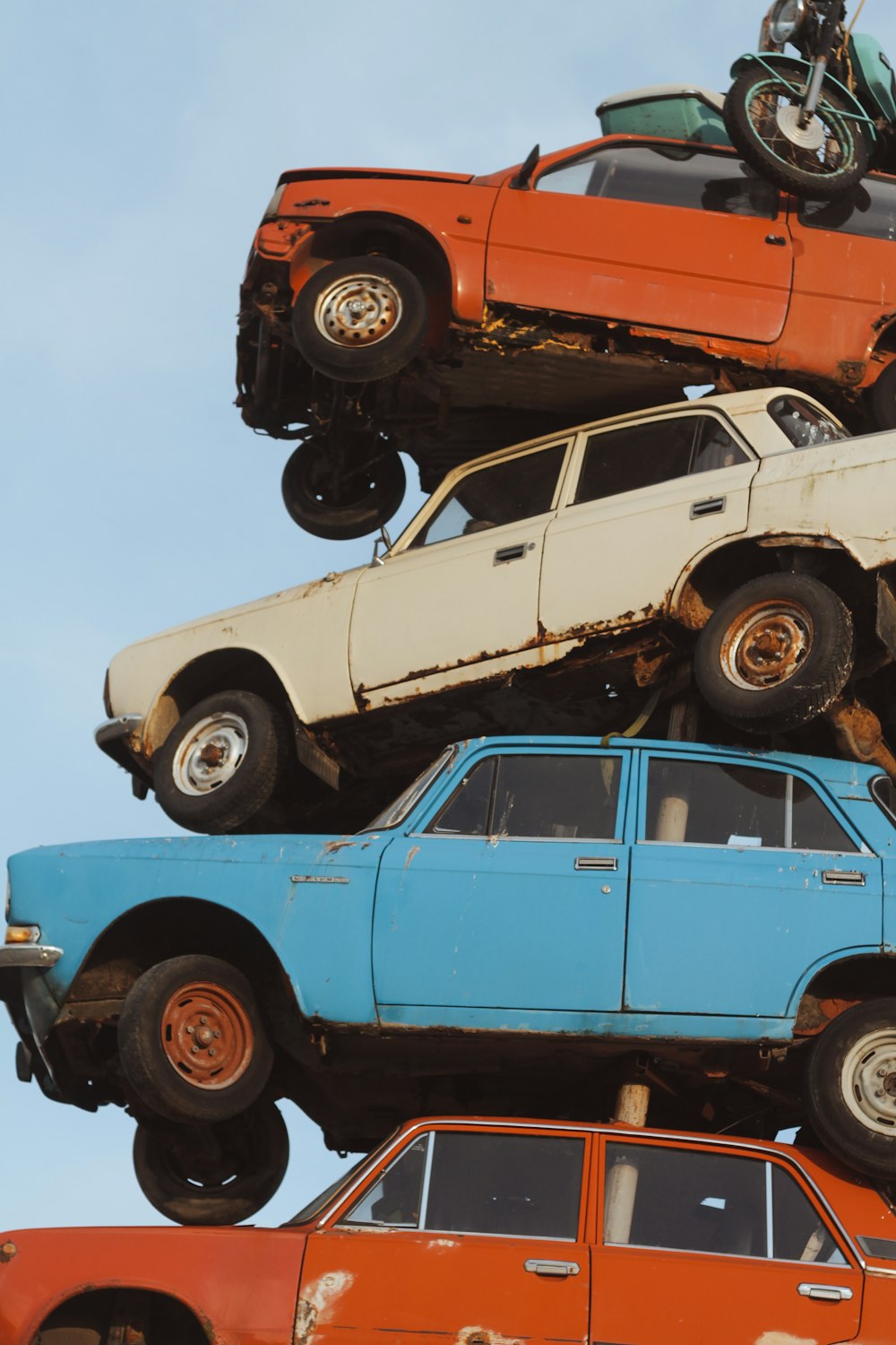 a pile of old cars and trucks stacked on top of each other