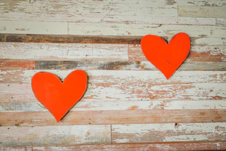 two red hearts on a white wooden background