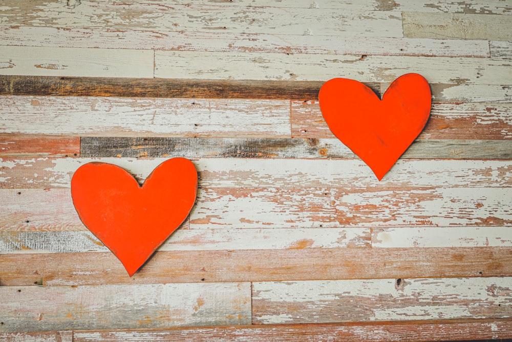 two red hearts on a white wooden background