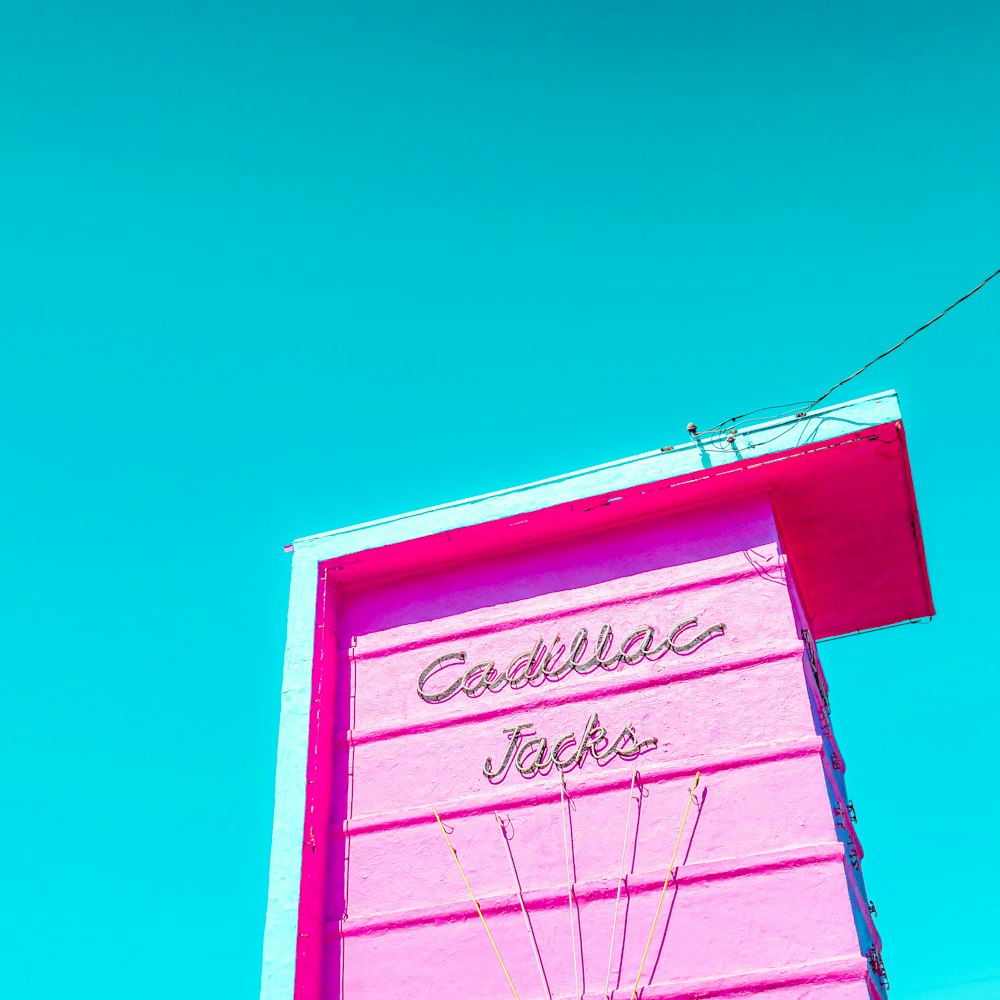 キャデラックモーテルと書かれた看板のあるピンクの建物