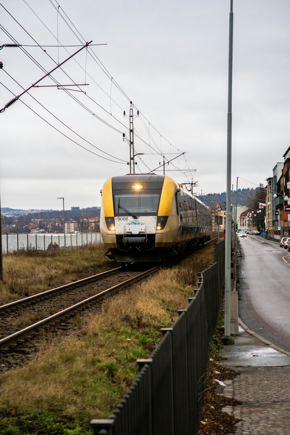 a yellow and white train traveling down train tracks