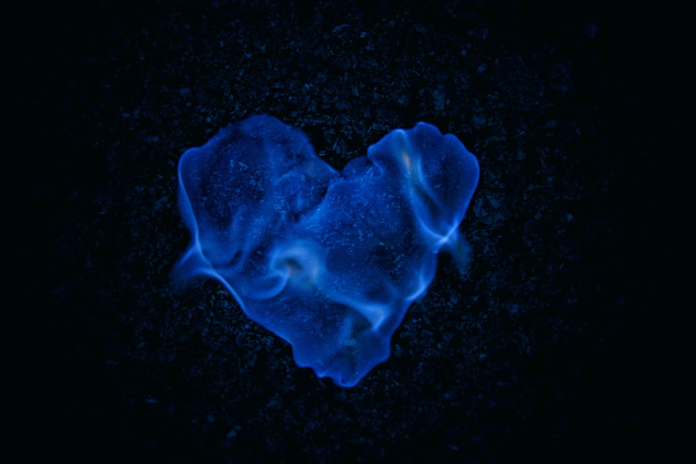 a blue heart shaped object on a black background