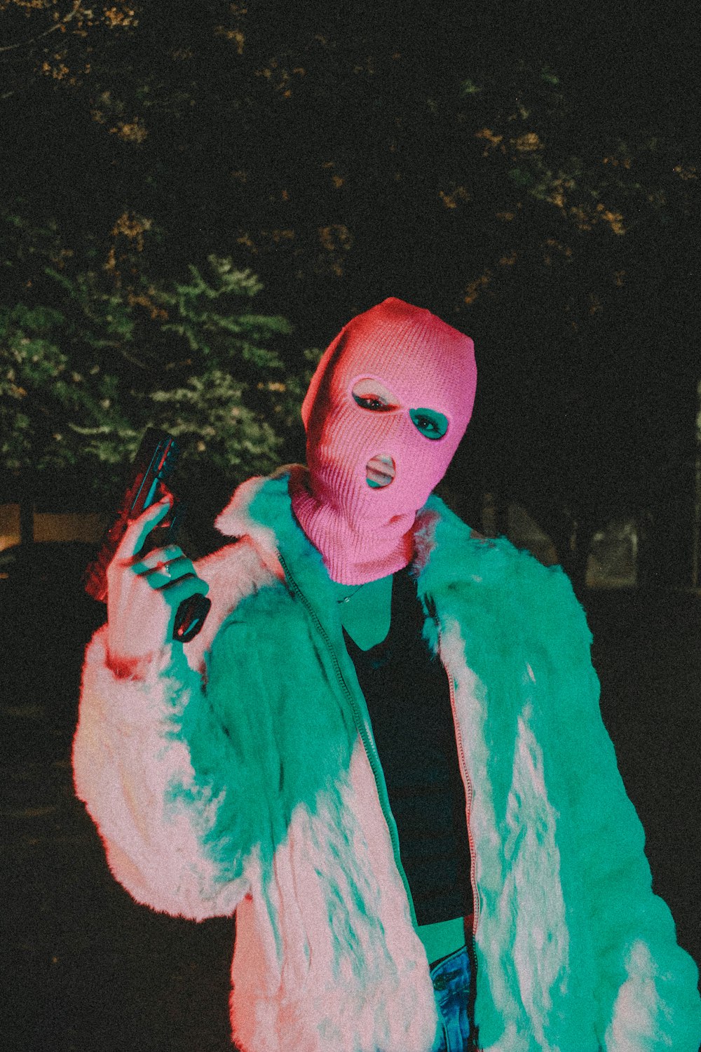 a man in a pink mask holding a cell phone