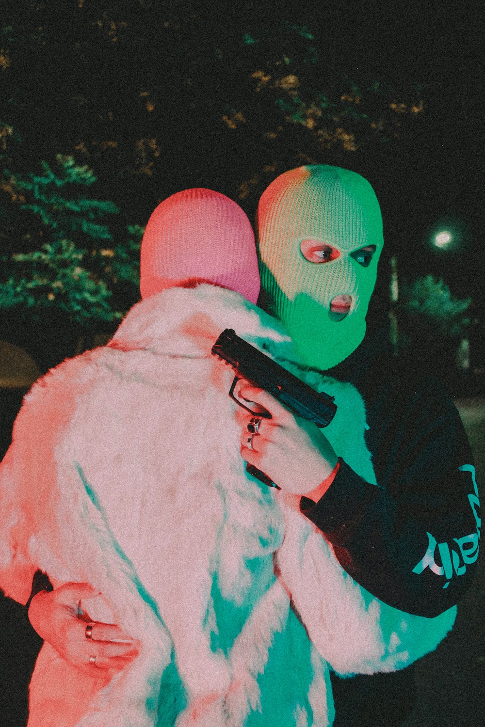 a man in a neon mask holding a woman in a fur coat