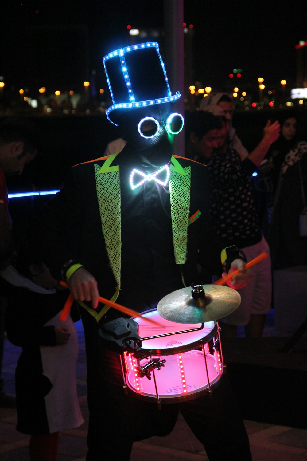 a man in a top hat and bow tie holding a drum