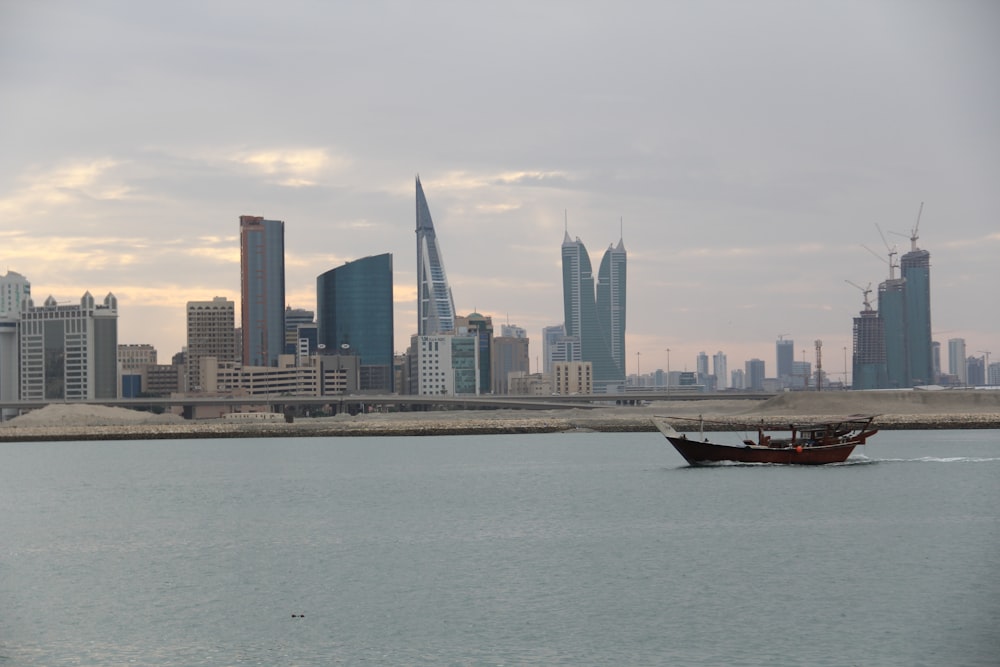 a boat in a body of water with a city in the background