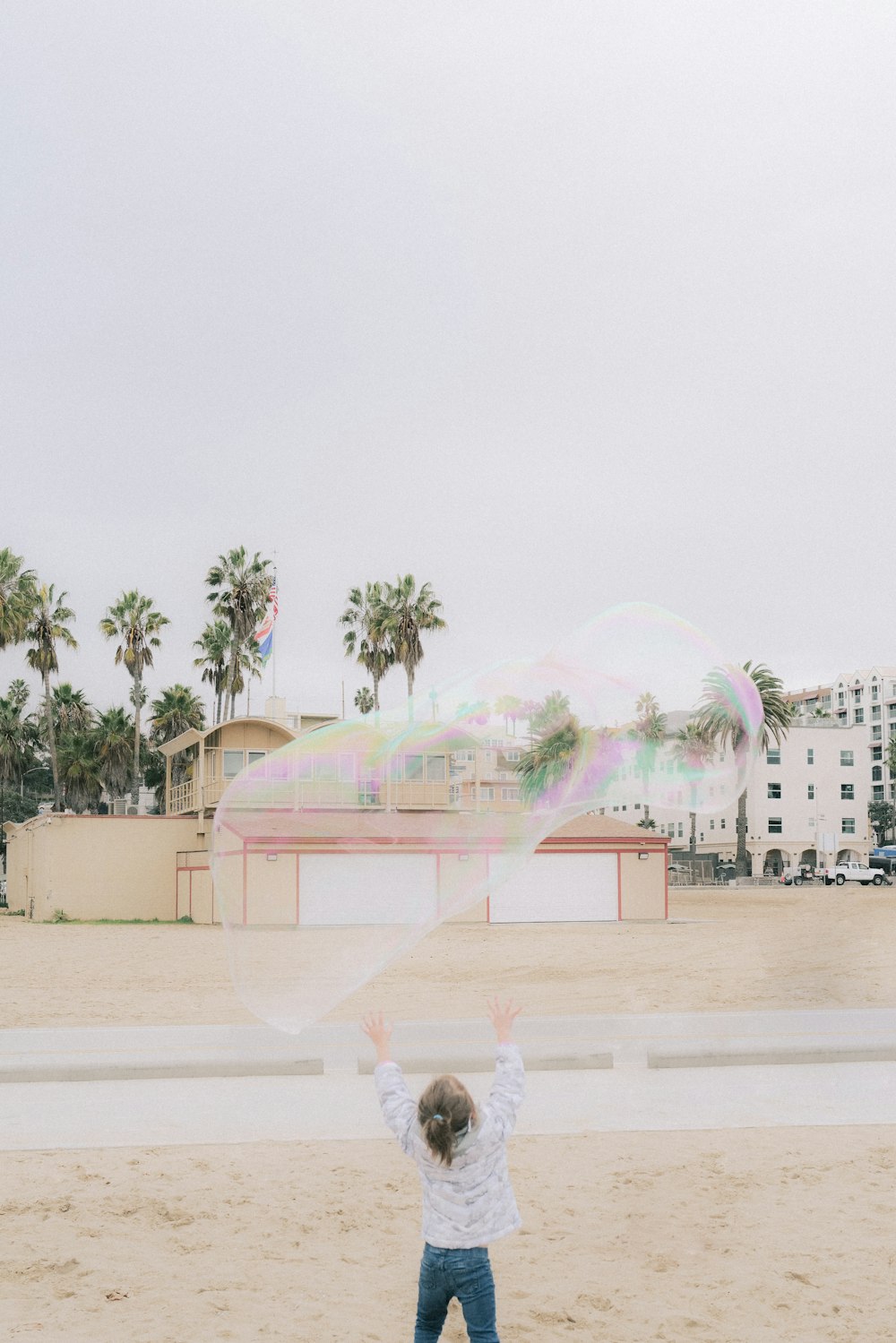 a little boy standing on top of a sandy beach