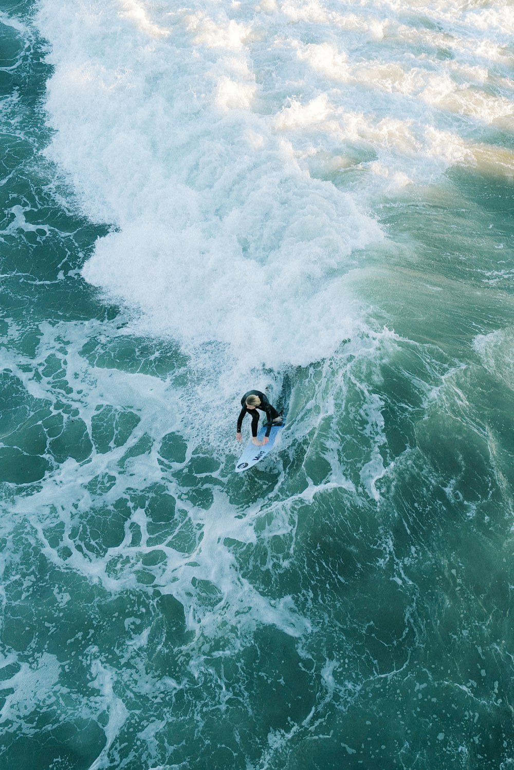 a man riding a wave on top of a surfboard